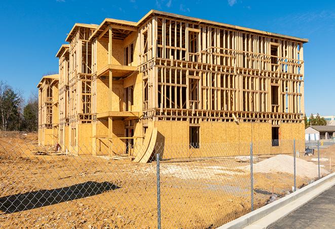 a temporary chain link fence in front of a building under construction, ensuring public safety in Harvest, AL